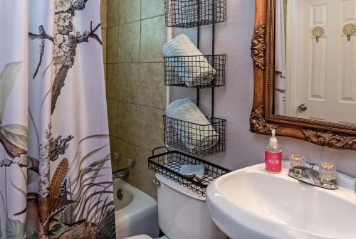 a bathroom with a sink and a toilet and a mirror at Silver Heart Inn & Cottages in Independence