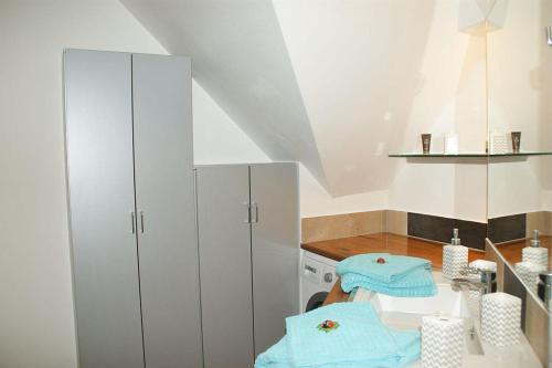 a kitchen with white cabinets and blue towels on a table at Ferienwohnung Seeblick in Glücksburg