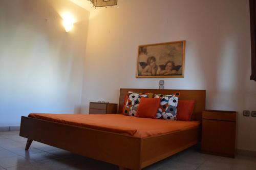 a bedroom with a bed with orange sheets and pillows at United blue Resorts - White Sand in Karteros