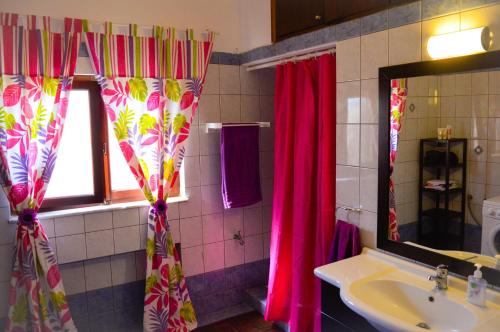 a bathroom with pink shower curtains and a sink at United blue Resorts - White Sand in Karteros