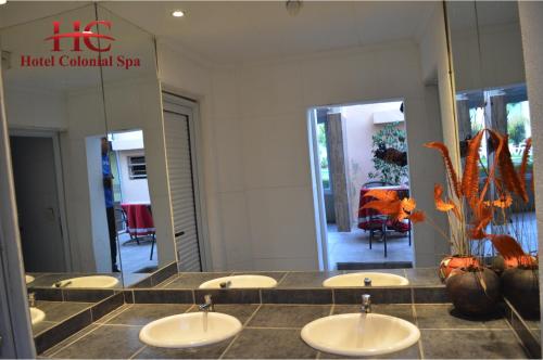 a bathroom with four sinks and a large mirror at HOTEL COLONIAL in Villa Carlos Paz