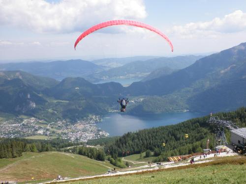 a person is flying a parachute over a mountain at Ferienwohnung Claudia in Faistenau