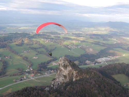 a person in a parachute flying over a mountain at Ferienwohnung Claudia in Faistenau