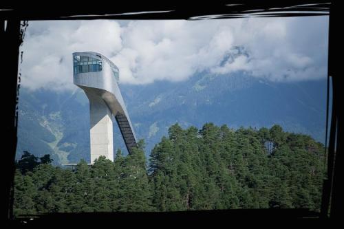 a tall building in the middle of a forest of trees at Wessely Appartements am Golfplatz in Innsbruck