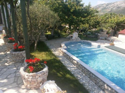 una piscina con piante e fiori in un cortile di KATY&MLADEN a Baška