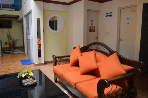 an orange couch with orange pillows in a living room at Le Ciel d'Uyuni in Uyuni