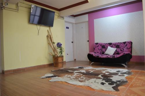 a living room with a purple couch and a tv at Le Ciel d'Uyuni in Uyuni