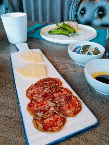 a table with a plate of food with cheese and vegetables at 小小邸 Small Hotel in Luodong