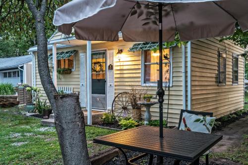 a table with an umbrella in front of a house at Silver Heart Inn & Cottages in Independence