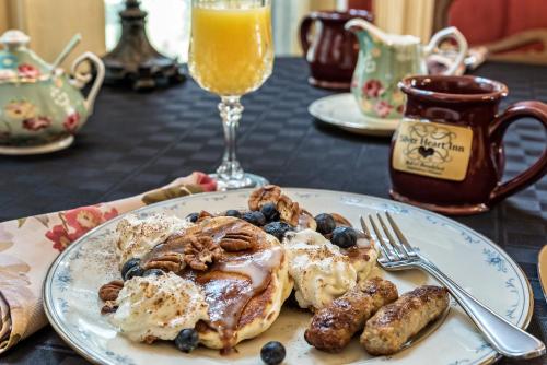 a plate of breakfast food with pancakes and blueberries at Silver Heart Inn & Cottages in Independence