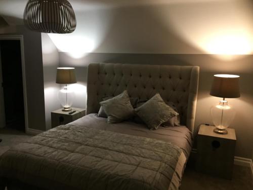 a bedroom with a large bed with two lamps at Four Winds,Kinsale Town,Exquisite holiday homes,sleeps 26 in Kinsale