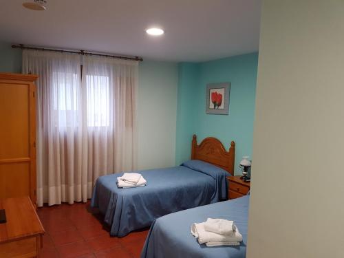 1 dormitorio con 2 camas y toallas. en HOSTAL ITXASO-ENEA, en Aoiz