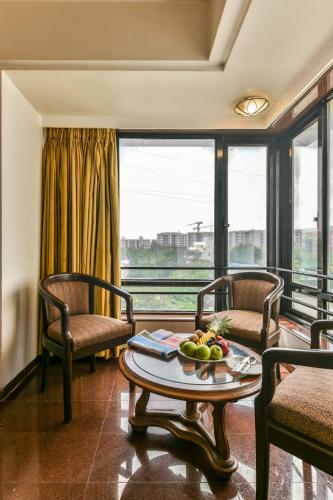 una habitación con 2 sillas y una mesa con fruta. en The Paradise By Tunga, en Bombay