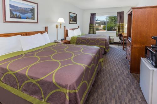 a hotel room with two beds and a television at Super 8 by Wyndham Central Pt Medford in Central Point