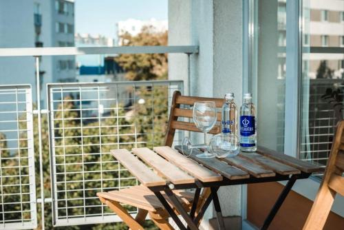 a wooden table with wine glasses and bottles on a balcony at New apartament very close to the city centre in Vilnius