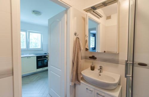a bathroom with a sink and a mirror at Apartment Tasha's Home in Opatija