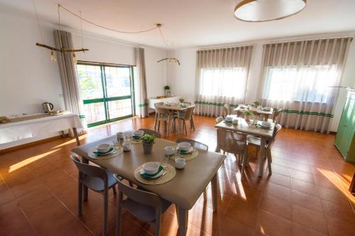 a dining room with tables and chairs and windows at Villa Nova Nautic & Nature in Eira do Chão