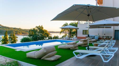 una piscina con sillas y sombrillas y un sistema de jardinería en Villa Nova Nautic & Nature, en Eira do Chão