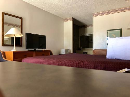 Habitación de hotel con cama y TV de pantalla plana. en Kewanee Motor Lodge, en Kewanee