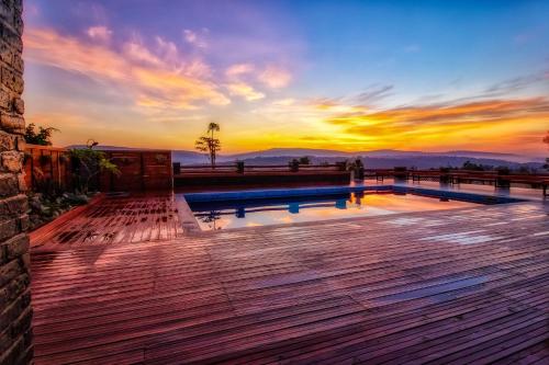a pool on a deck with a sunset in the background at Peponi Living Spaces in Kigali
