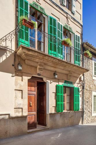 a building with green shutters and a door at Senda Caimari in Caimari