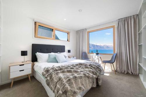 a bedroom with a large bed with a view of the ocean at The Lairds Bothy in Queenstown