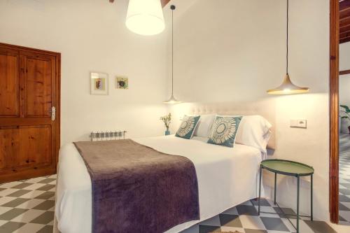 a bedroom with a large white bed and a table at Senda Caimari in Caimari