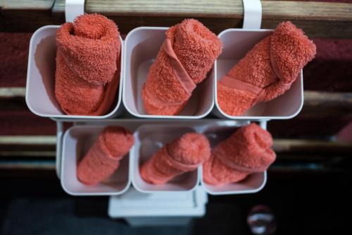 a refrigerator with four containers filled with red towels at BABhouse Loja do Cavalo - Coração do Douro in São João da Pesqueira