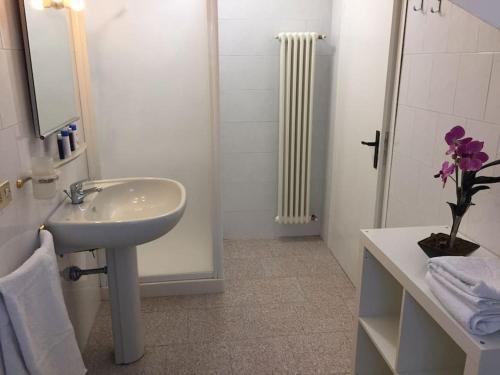 ein weißes Bad mit einem Waschbecken und einer Dusche in der Unterkunft Casa vicino al mare in Rimini