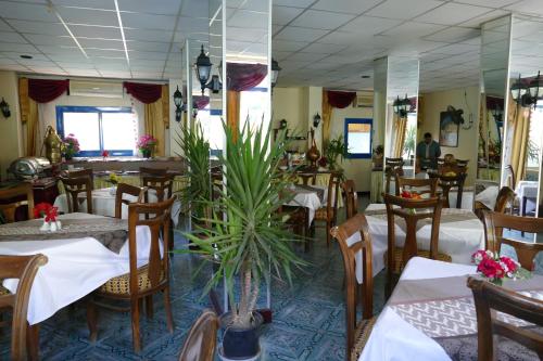 a restaurant with tables and chairs and a plant at El Gezira Garden Hotel Luxor in Luxor