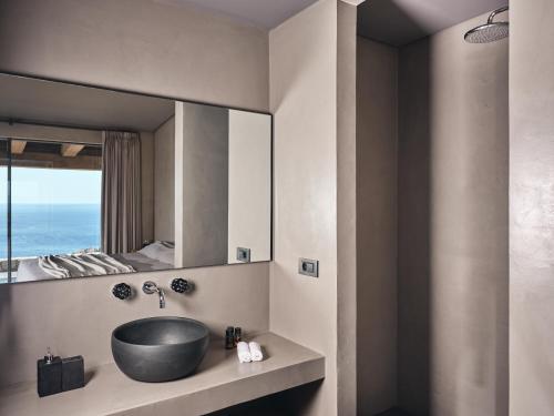 a bathroom with a sink and a large mirror at Vais Luxury Villas in Agios Nikolaos