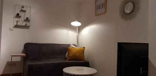 ein Wohnzimmer mit einem Sofa und einer Lampe in der Unterkunft l’appart Malouin à 50M de la plage in Dunkerque