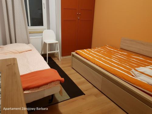 チェホチネクにあるApartamenty Zdrojoweのベッドルーム1室(ベッド1台、椅子付)