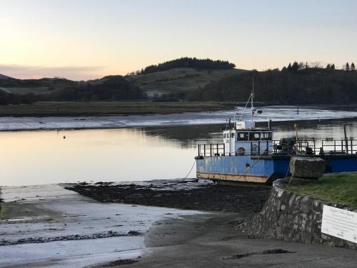 a boat sitting on the shore of a river at Kipplochan in Dalbeattie