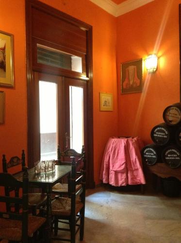 a dining room with orange walls and a table at Hostal Sierpes in Seville