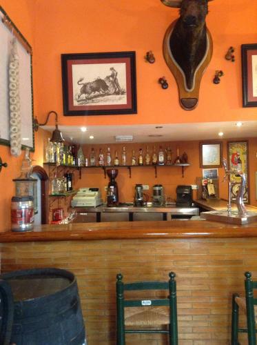 a bar in a restaurant with a counter and chairs at Hostal Sierpes in Seville
