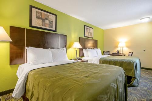 two beds in a hotel room with green walls at Quality Inn & Suites Glenmont - Albany South in Glenmont