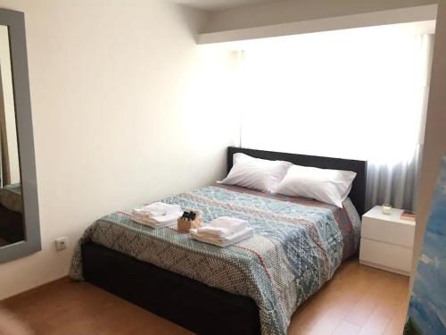 ein Schlafzimmer mit einem Bett mit zwei Handtüchern darauf in der Unterkunft Maestro Appartment in Porto
