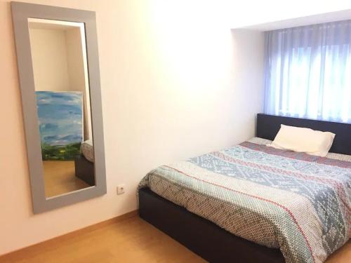 ein Schlafzimmer mit einem Bett und einem großen Spiegel in der Unterkunft Maestro Appartment in Porto