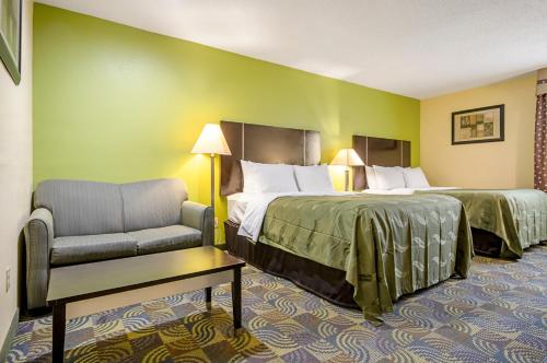 a hotel room with two beds and a chair at Quality Inn & Suites Glenmont - Albany South in Glenmont