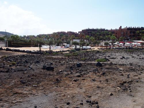 a beach with a bunch of rocks on the ground at Maravilloso y tranquilo alojamiento en el Palm-Mar in Palm-mar