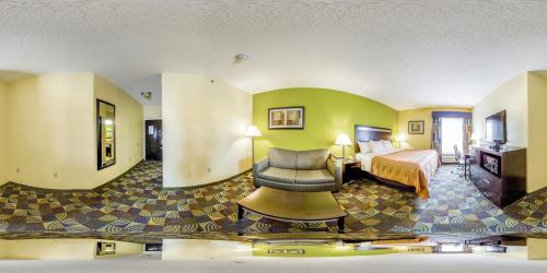a hotel room with a bed and a chair at Quality Inn & Suites Glenmont - Albany South in Glenmont