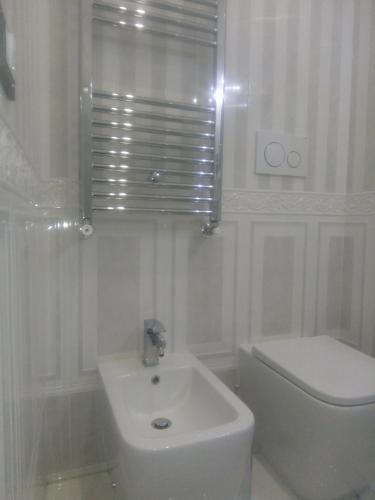a white bathroom with a sink and a toilet at Barberini Dream in Rome