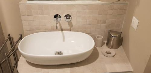 a white sink in a bathroom with a window at Appartamento Pertinace Centro Storico Alba in Alba