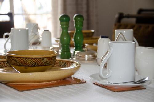 a table with cups and plates on a table at Hillside Manor in Bulawayo