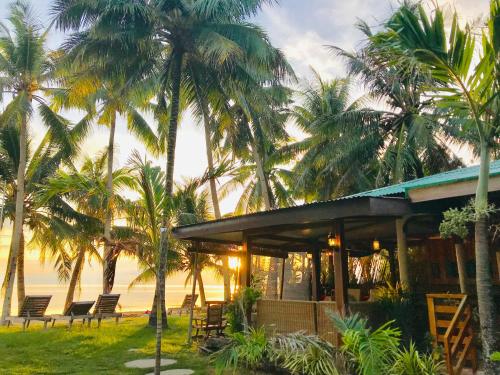 a house on the beach with palm trees at Charisma Beach Resort in Siquijor