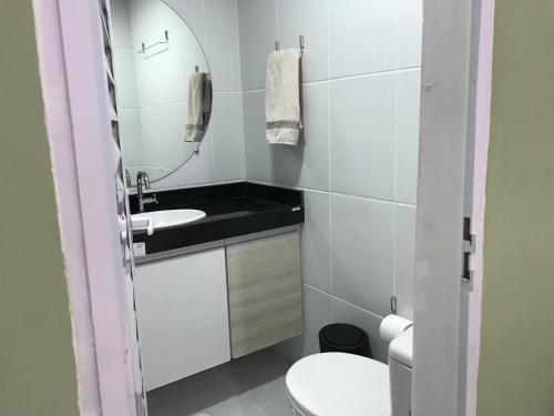 a bathroom with a sink and a mirror and a toilet at Mandakaru Residence- Chalé 14 in Porto De Galinhas