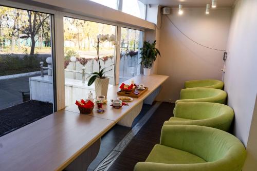 ハバロフスクにあるホテル オネガの緑の椅子とテーブル、窓が備わる客室です。