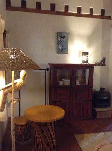 a table and a stool in a room with a lamp at Posada Yolihuani in Pátzcuaro