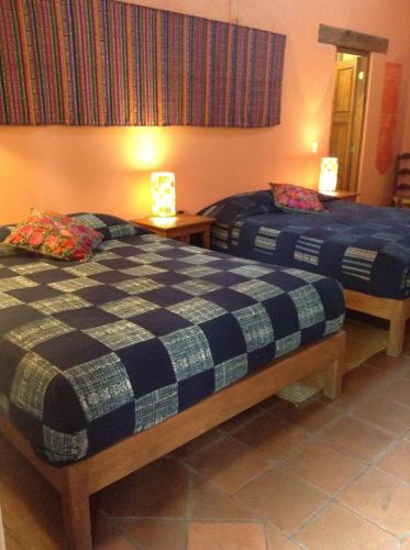 a bedroom with two beds and two lamps on tables at Posada Yolihuani in Pátzcuaro